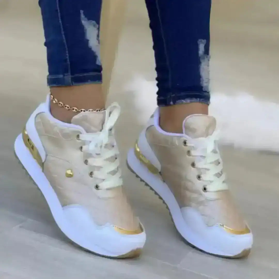 Women's lace-up sneakers with gold-colored accents, on-foot styling.