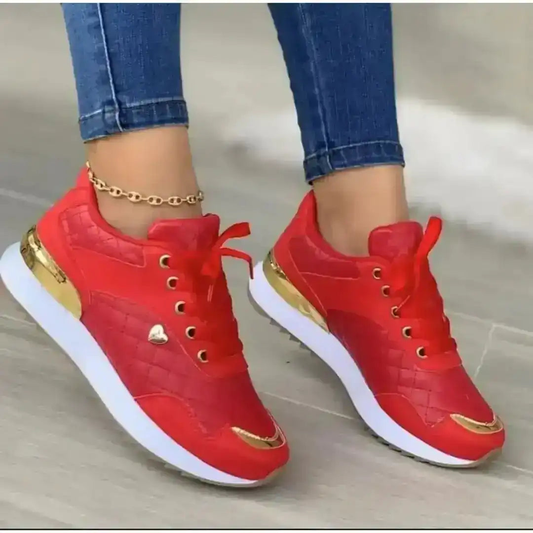 Women's lace-up sneakers with gold-colored accents, on-foot styling.
