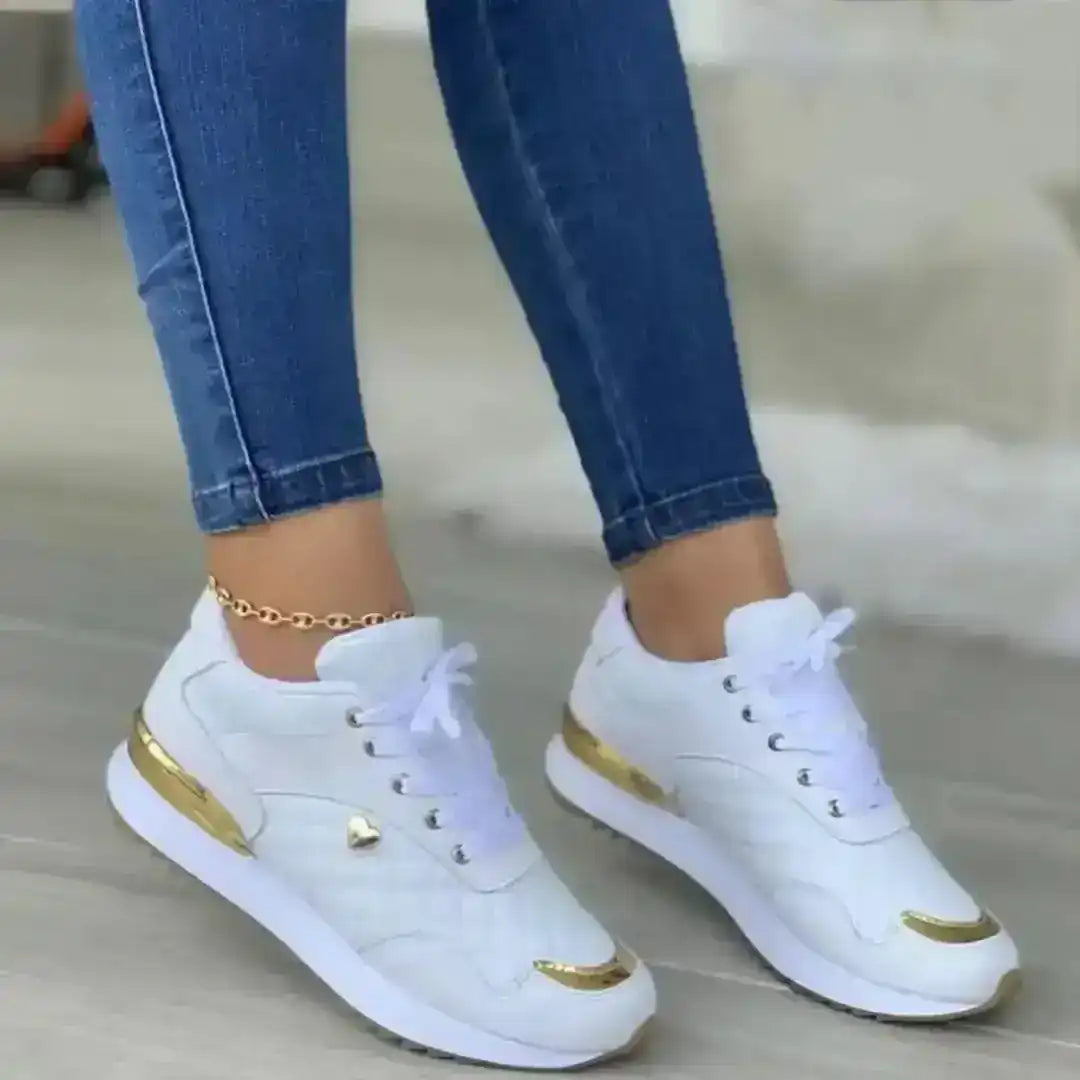 Women's lace-up sneakers with gold-colored accents, on-foot styling.