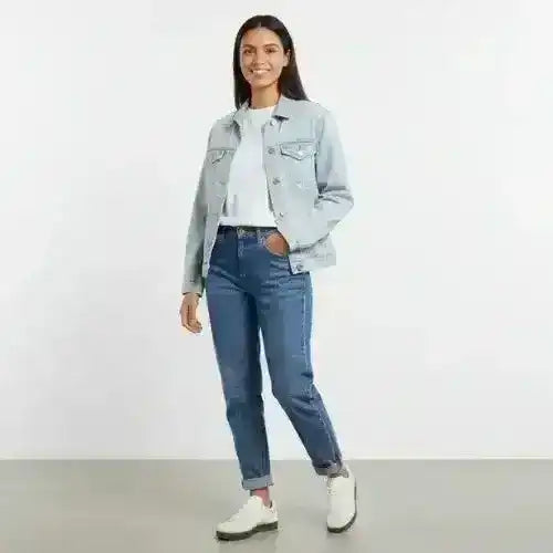 Model wearing a light denim jacket, white top and blue jeans.