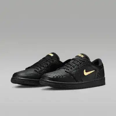 Black low-top sneakers with gold-colored swoosh details.