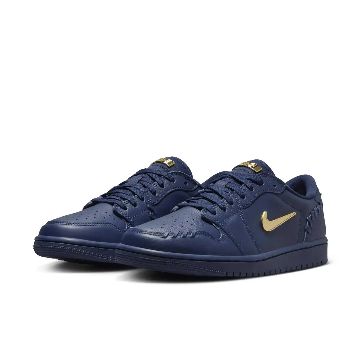 Navy low-top sneakers with gold-colored swoosh details.