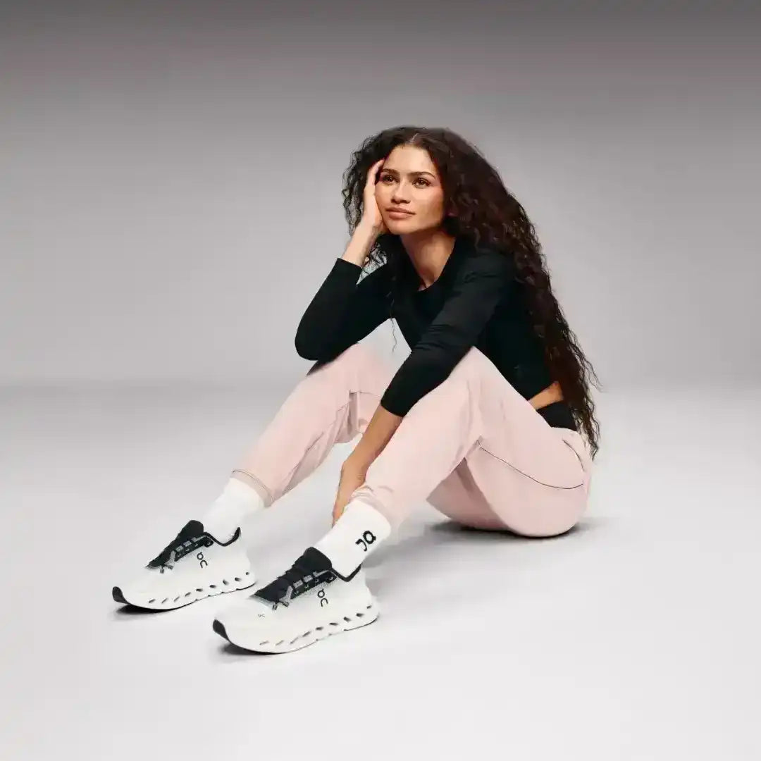 White and black lace-up sneakers with cutout-style midsoles.