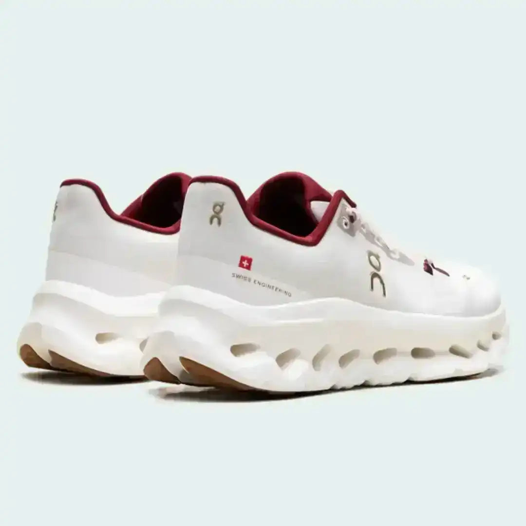 Off-white lace-up sneakers with red collar accents and cutout-style midsoles.
