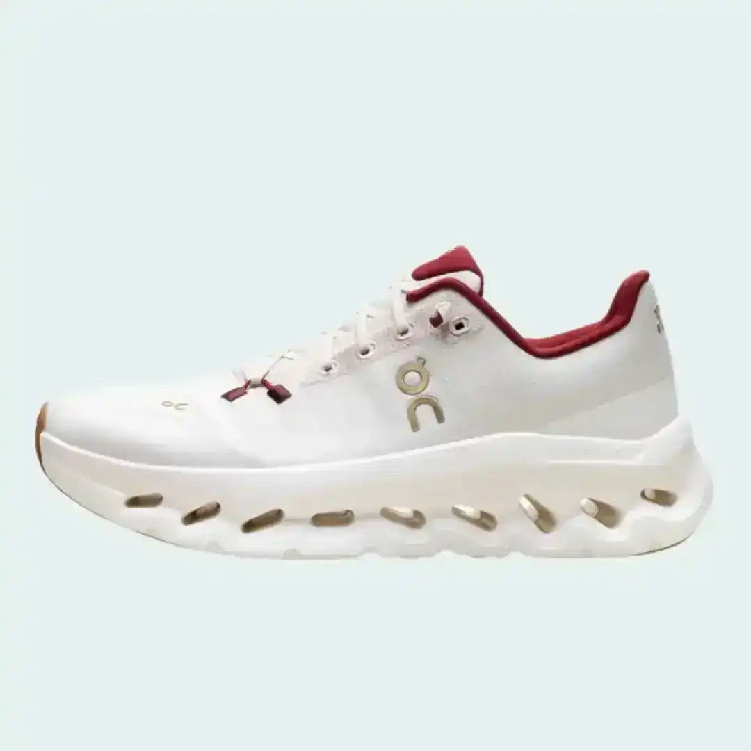 Off-white lace-up sneakers with red collar accents and cutout-style midsoles.