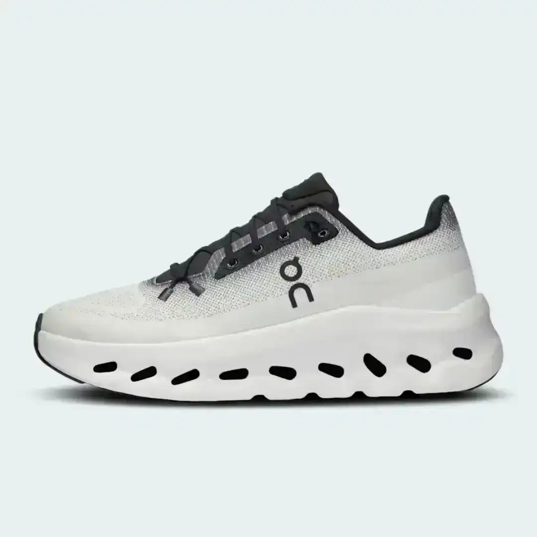 White and black lace-up sneakers with cutout-style midsoles.