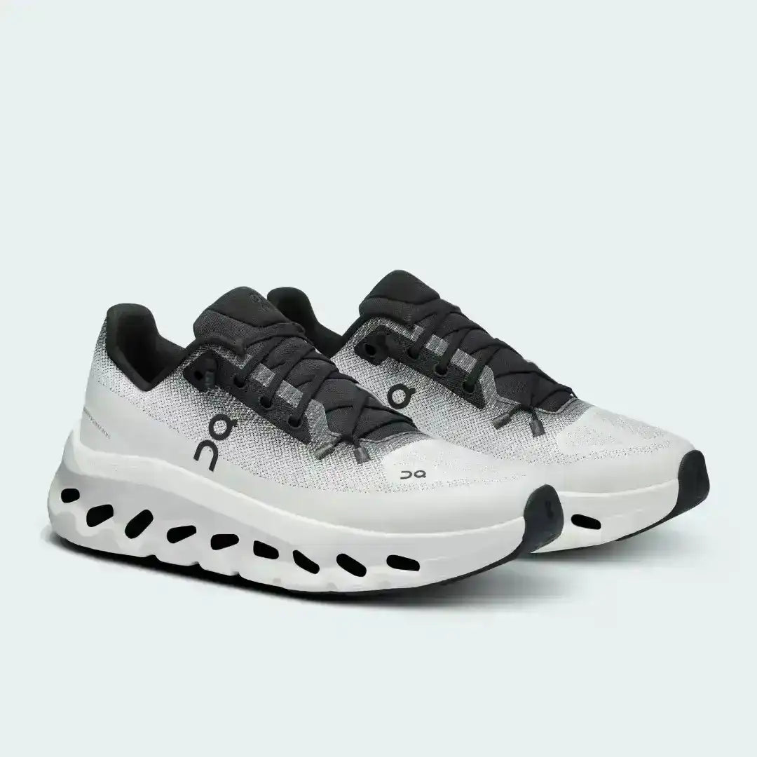 White and black lace-up sneakers with cutout-style midsoles.