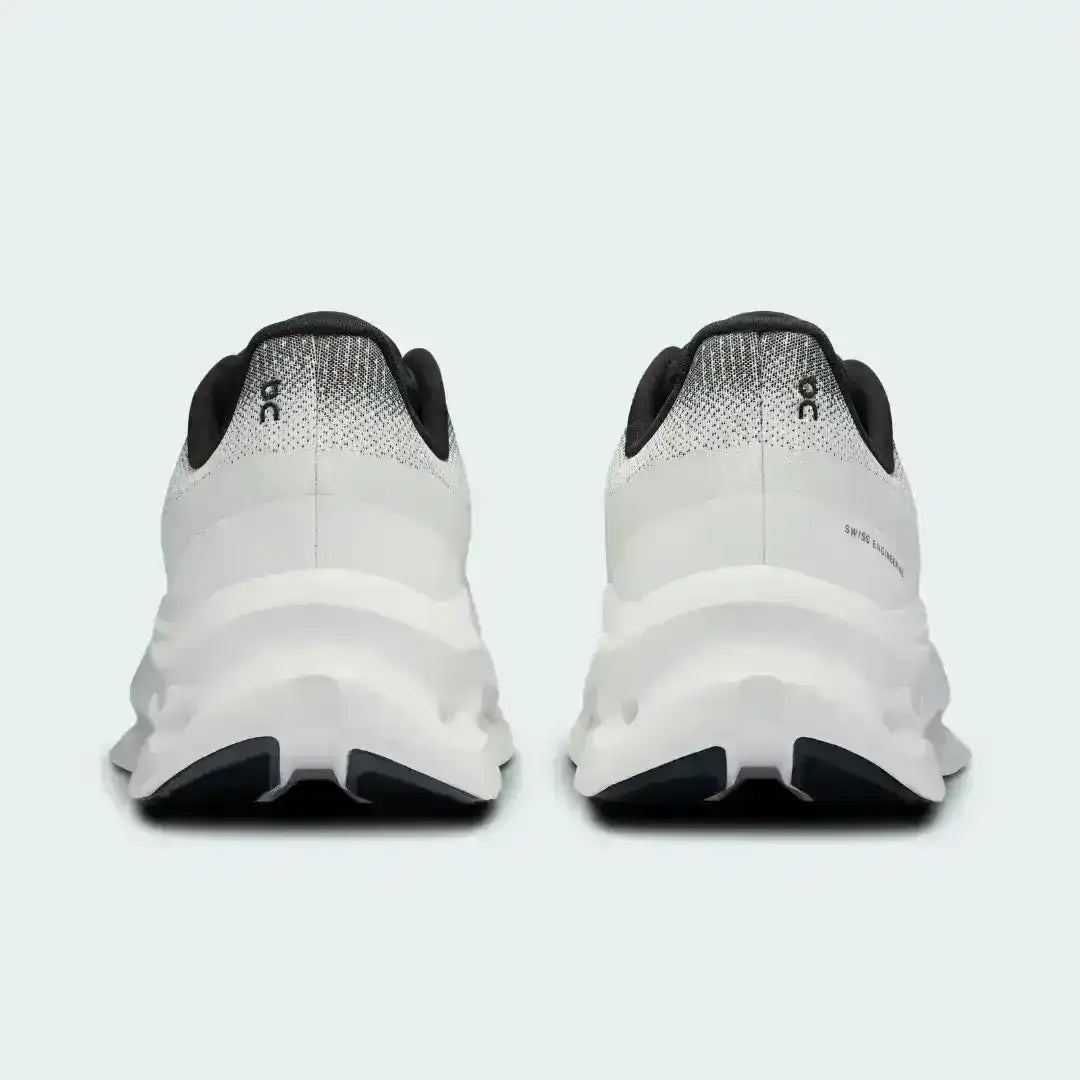 White and black lace-up sneakers with cutout-style midsoles.