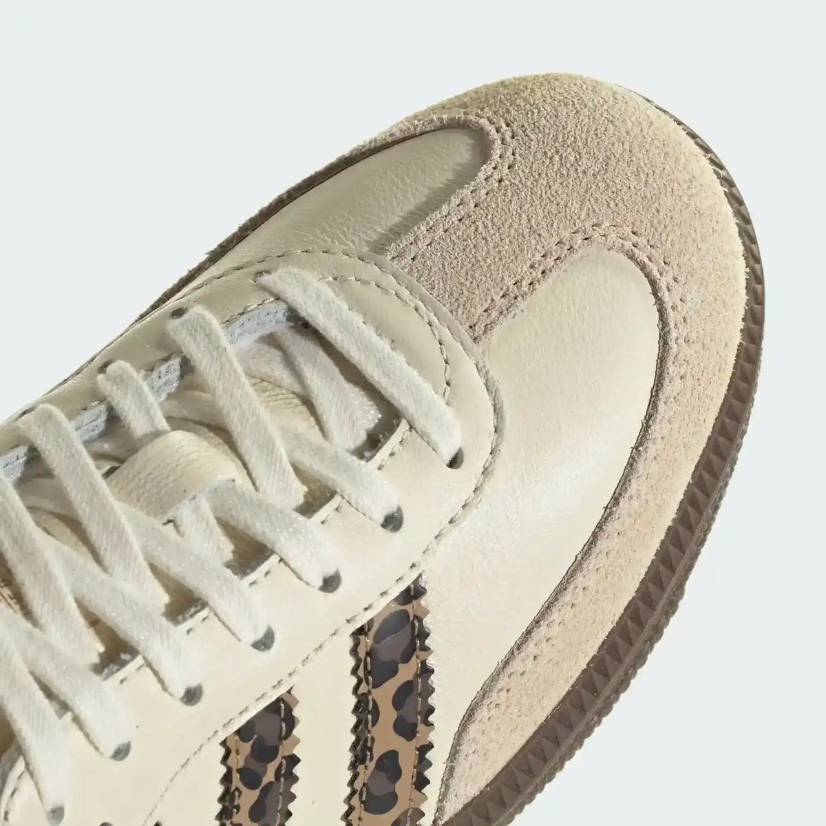 Cream low-top sneakers with leopard-pattern side stripes.