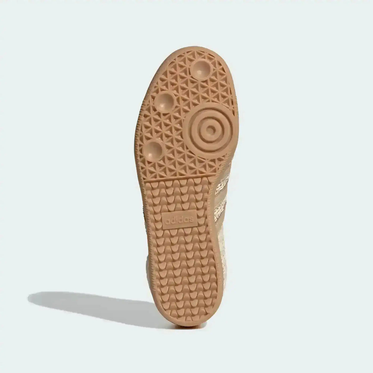 Gum-colored sneaker outsole with circular tread, bottom view.