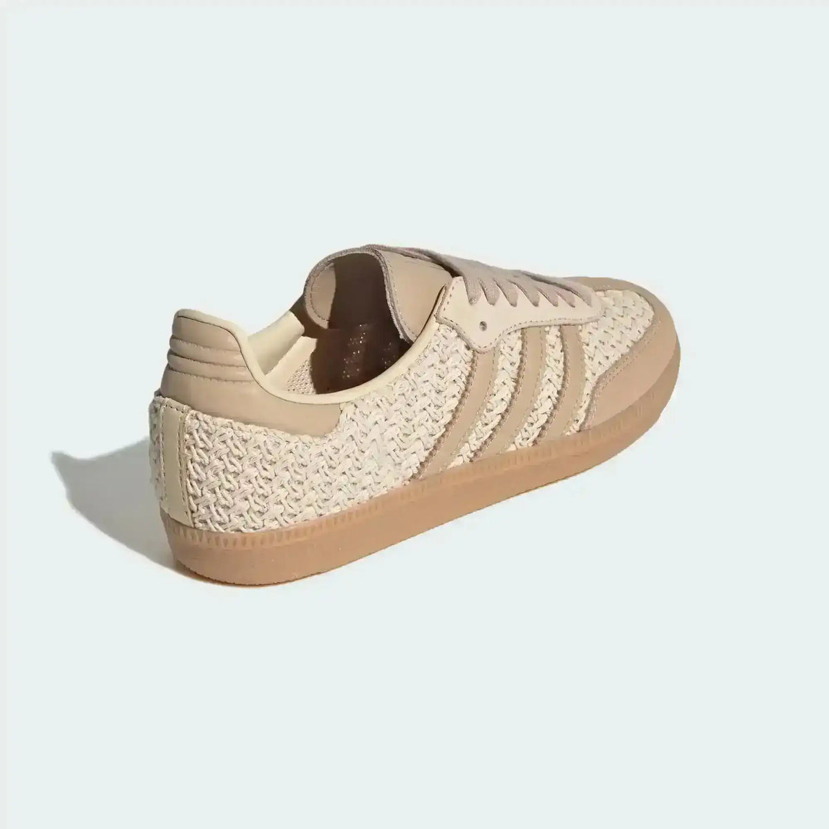 Beige woven-texture low-top sneakers with light stripes and gum soles.