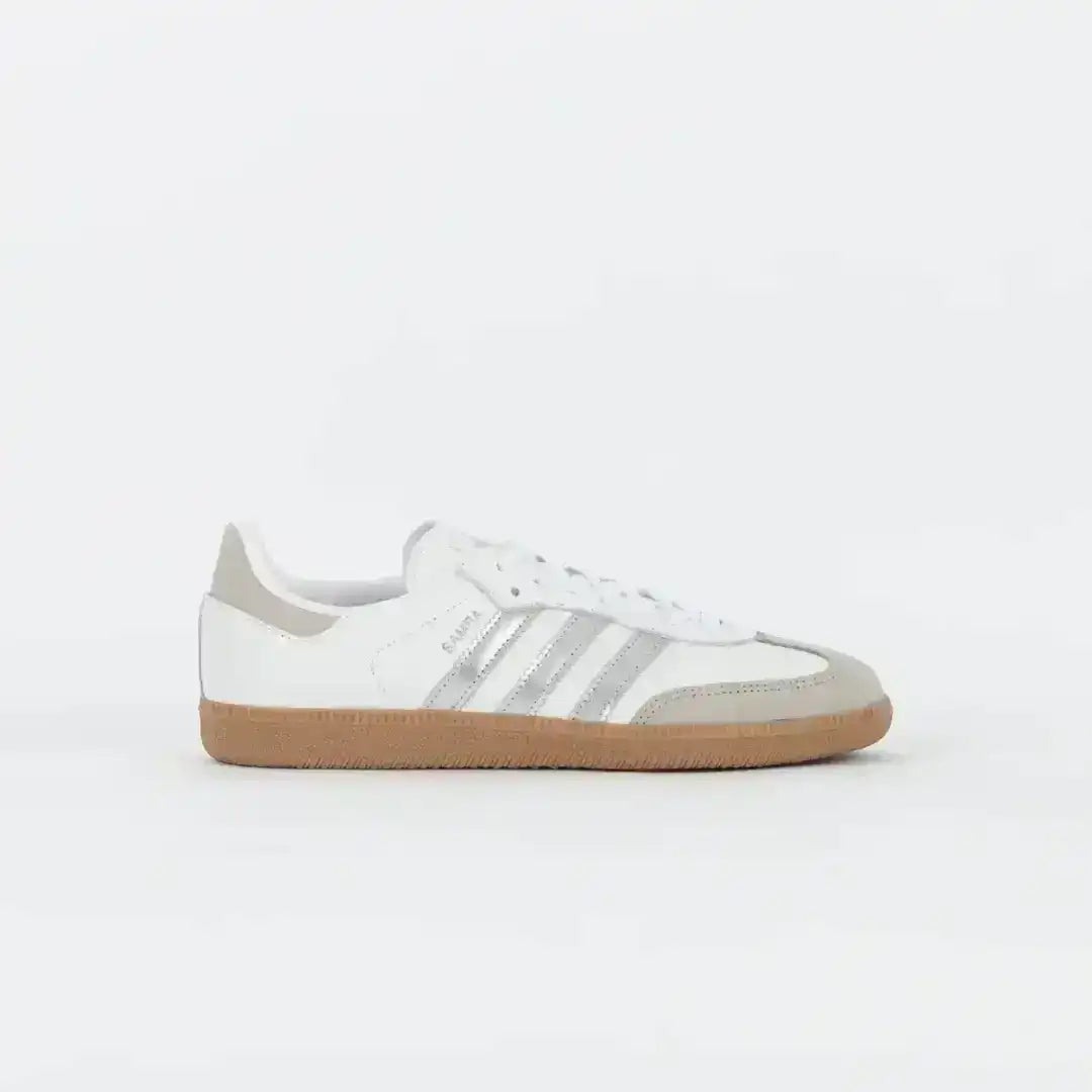 White and light gray three-stripe sneakers with gum soles.