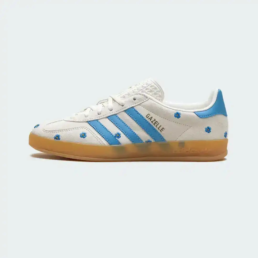 Adidas Gazelle white sneakers featuring embroidered blue flowers, textured suede upper, classic blue stripes and a comfortable gum bottom sole.