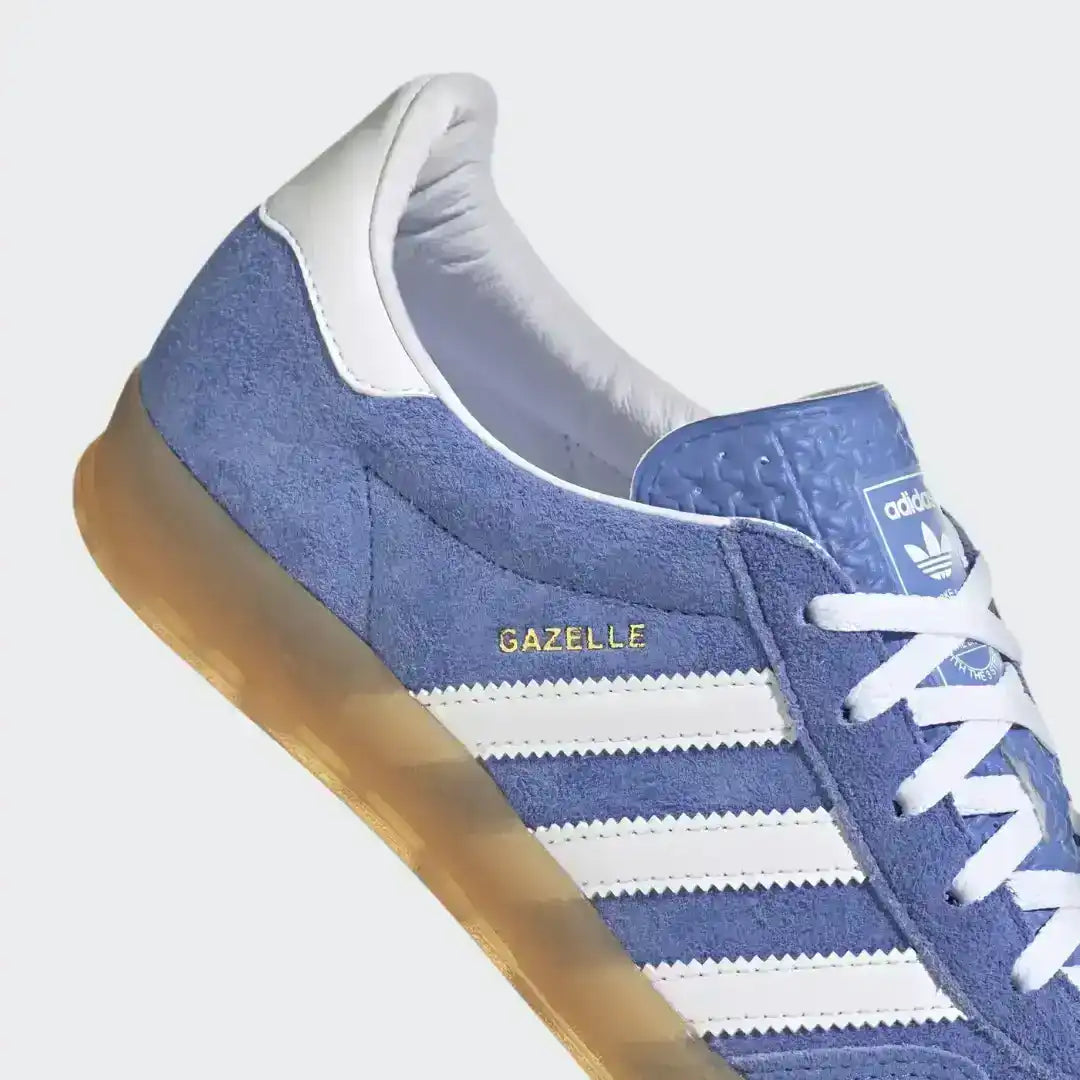 Adidas Gazelle Indoor trainers in a vibrant blue colorway, designed with a soft suede construction and a durable semi-transparent gum cupsole.