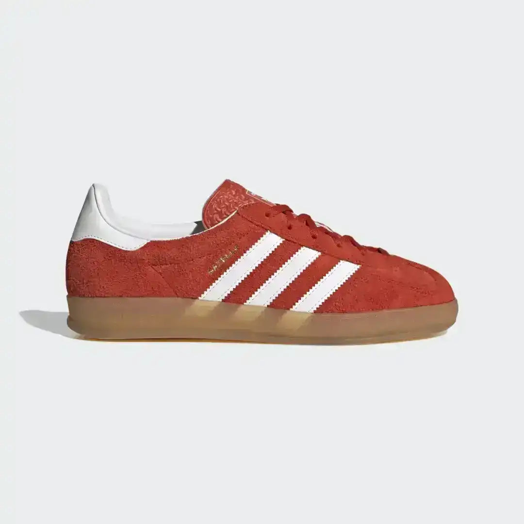 Red and white Adidas Gazelle Indoor sneakers with a gum sole, offering a classic terrace culture look with premium suede materials and authentic Adidas Originals detailing.