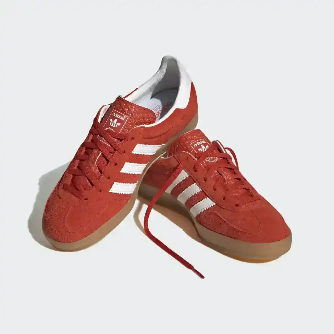 Fashionable Adidas Gazelle Indoor Red Gum sneakers featuring a rich suede upper, white heel counter, and gold metallic details, perfect for a casual retro-inspired outfit.