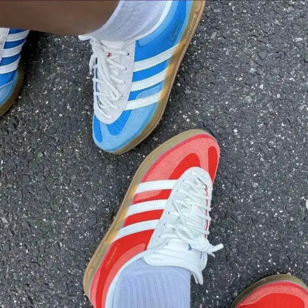Blue and red Adidas shoes on a pavement