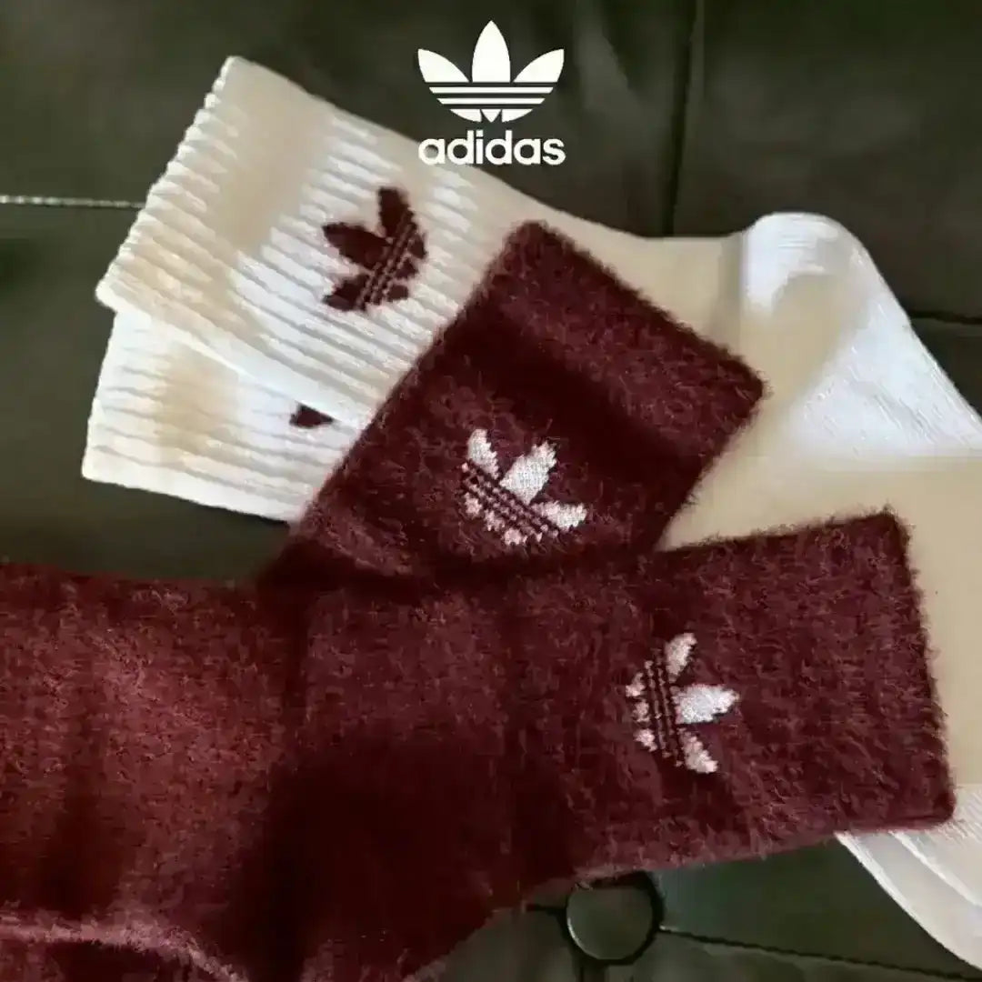 Adidas Originals plush knit socks featuring different colorways such as black, off-white, and terracotta, all adorned with the embroidered Trefoil emblem.