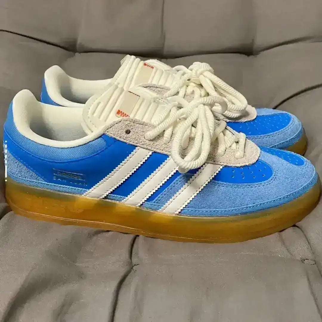Blue and white sneakers with brown soles on a gray surface