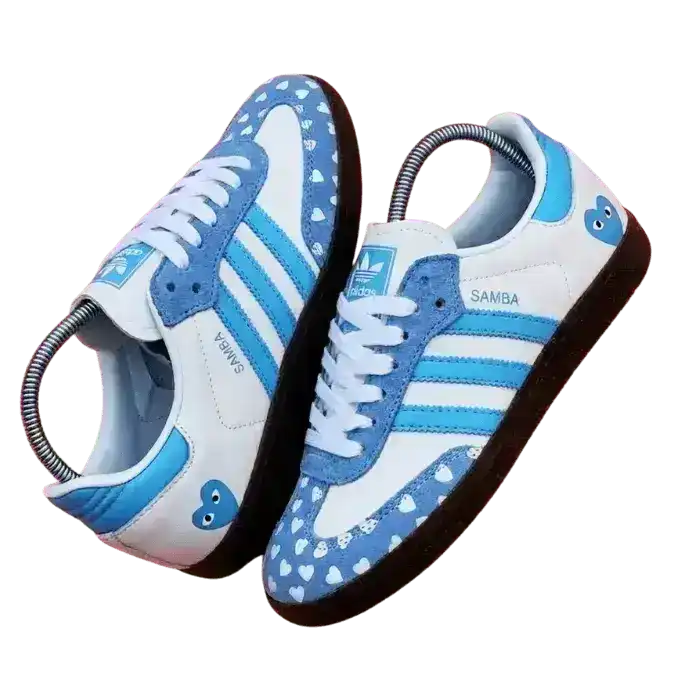 Custom Adidas Samba sneakers in white and light blue featuring a heart pattern on the toe box and gum soles.