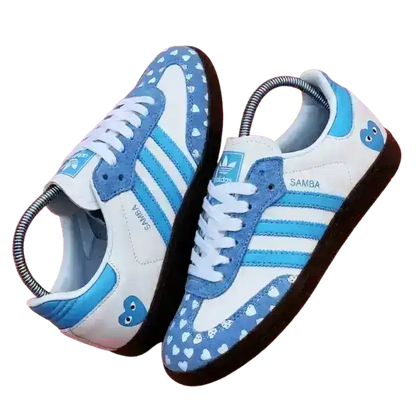 Custom Adidas Samba sneakers in white and light blue featuring a heart pattern on the toe box and gum soles.
