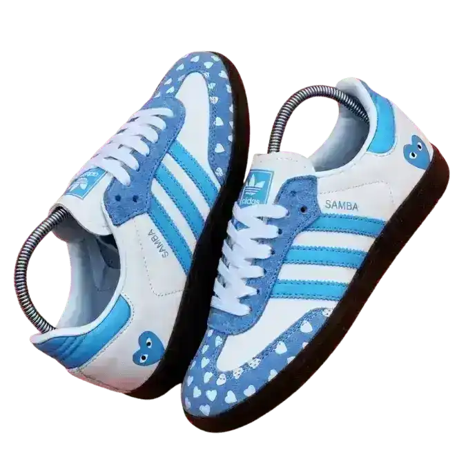 Light blue and white Adidas Samba OG shoes customized with a heart print suede toe cap and heart logo on the heel.