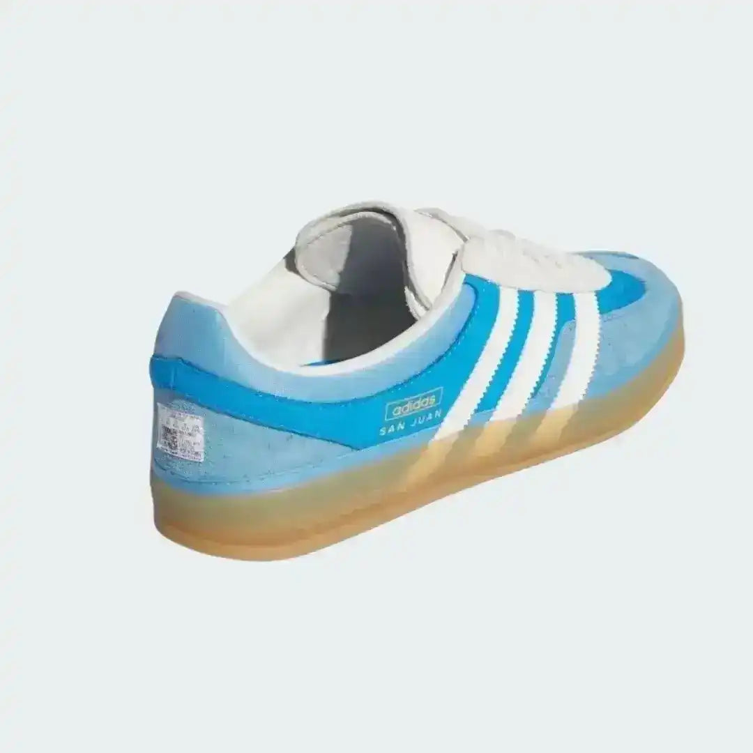 Blue and white sneaker with Adidas logo on a light gray background