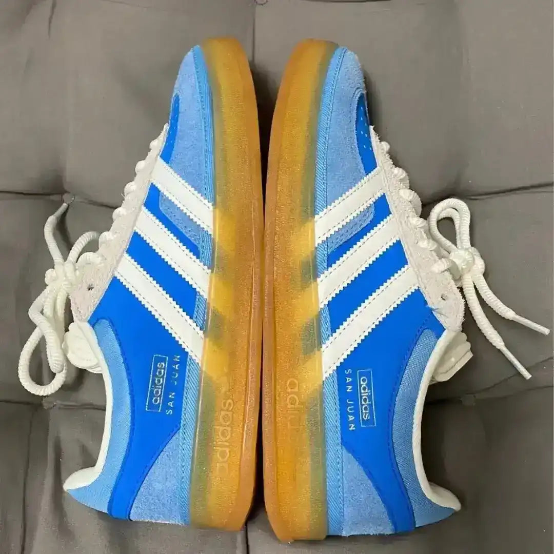 Blue and yellow Adidas sneakers on a gray surface