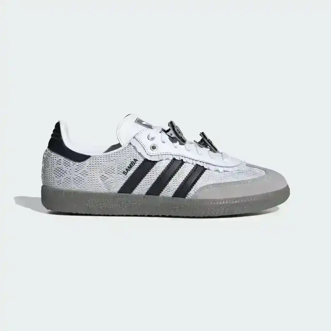 Custom Adidas Samba sneakers in white with black stripes, showcasing a unique lacing system with striped ribbons and small black flower embellishments.