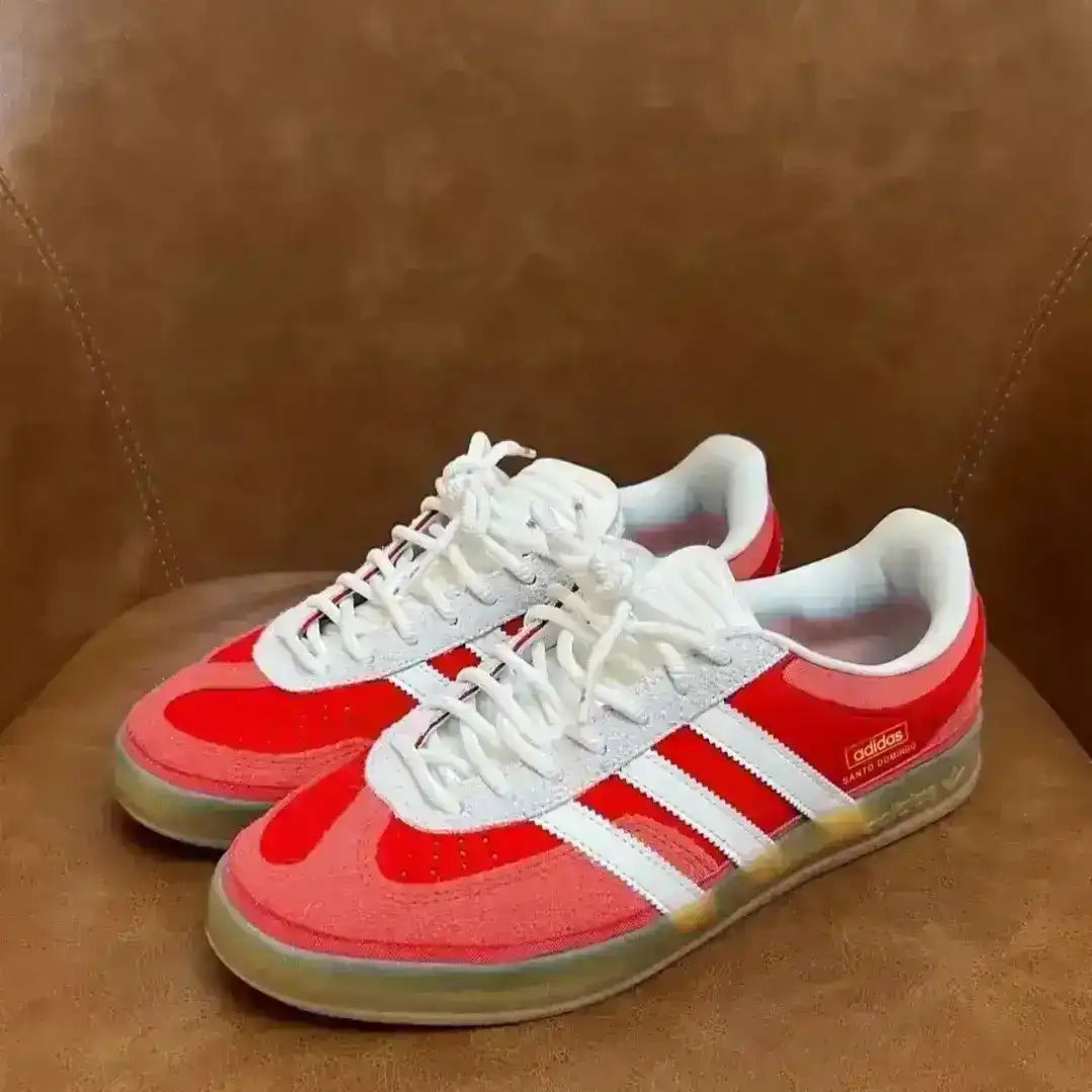 Red and white Adidas sneakers on a brown leather chair