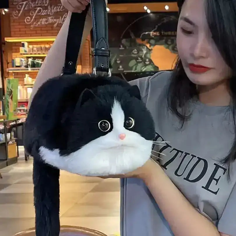 Fuzzy cat-shaped handbag with a handle and long tail detail.