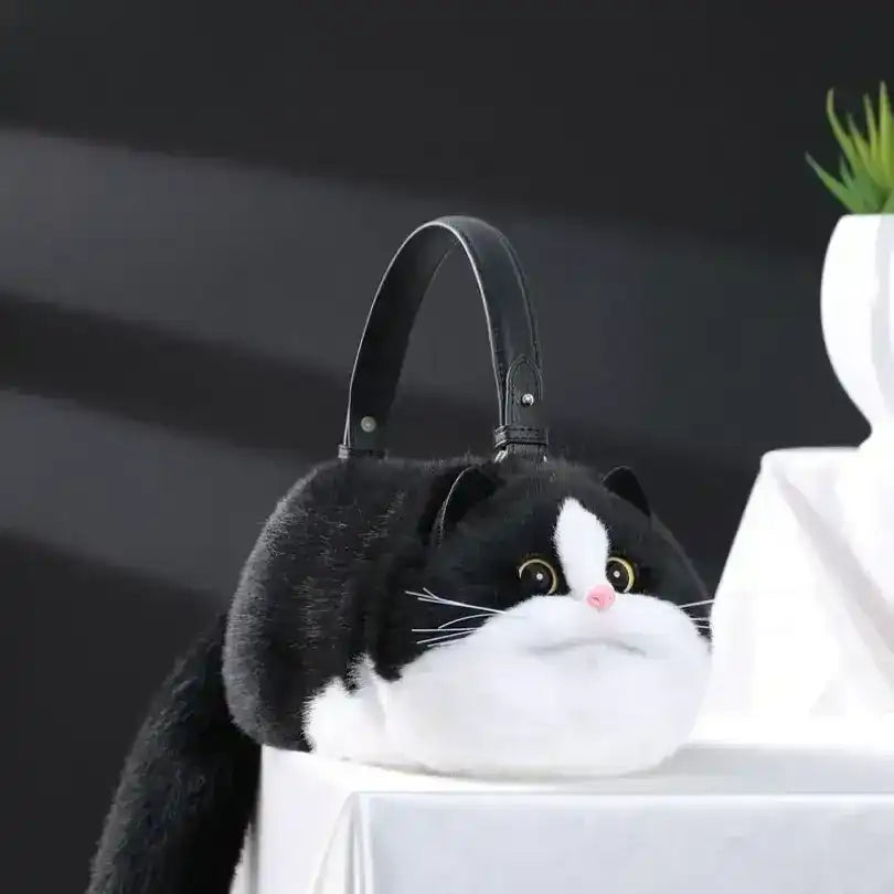 Fuzzy cat-shaped handbag with a handle and long tail detail.