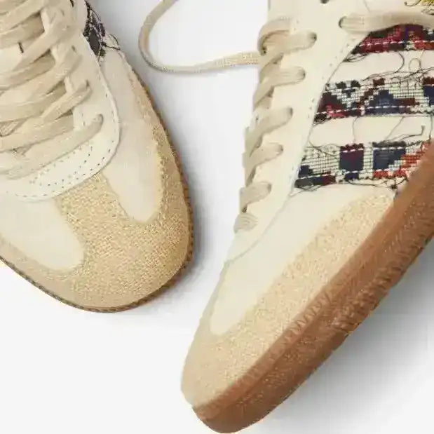 Cream low-top sneakers with multicolored patterned panels.