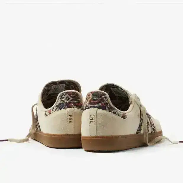Cream low-top sneakers with multicolored patterned panels.