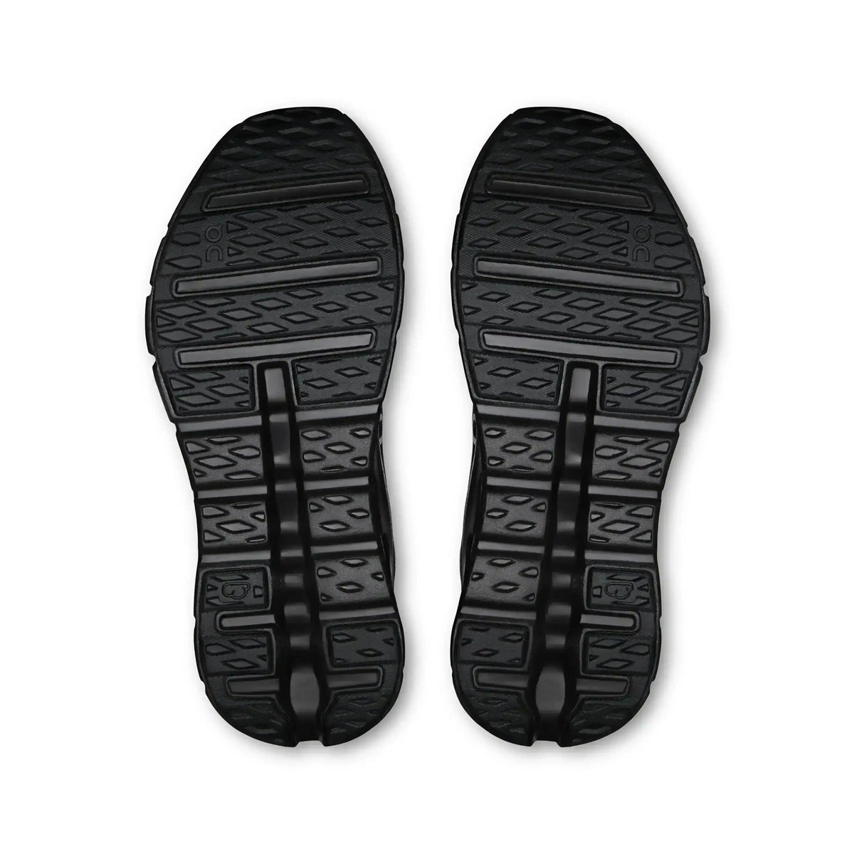 Black sneaker outsoles with segmented tread, bottom pair view.