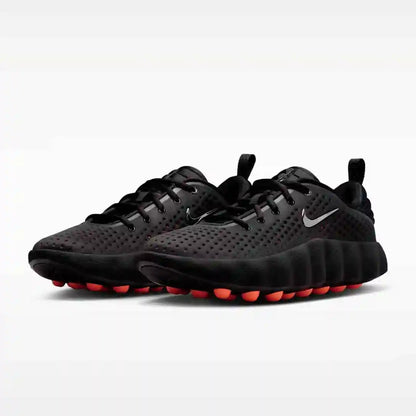Black mesh-panel sneakers with orange sole pods, pair view.