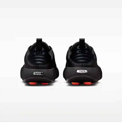 Black sneakers with orange sole pods, rear pair view.
