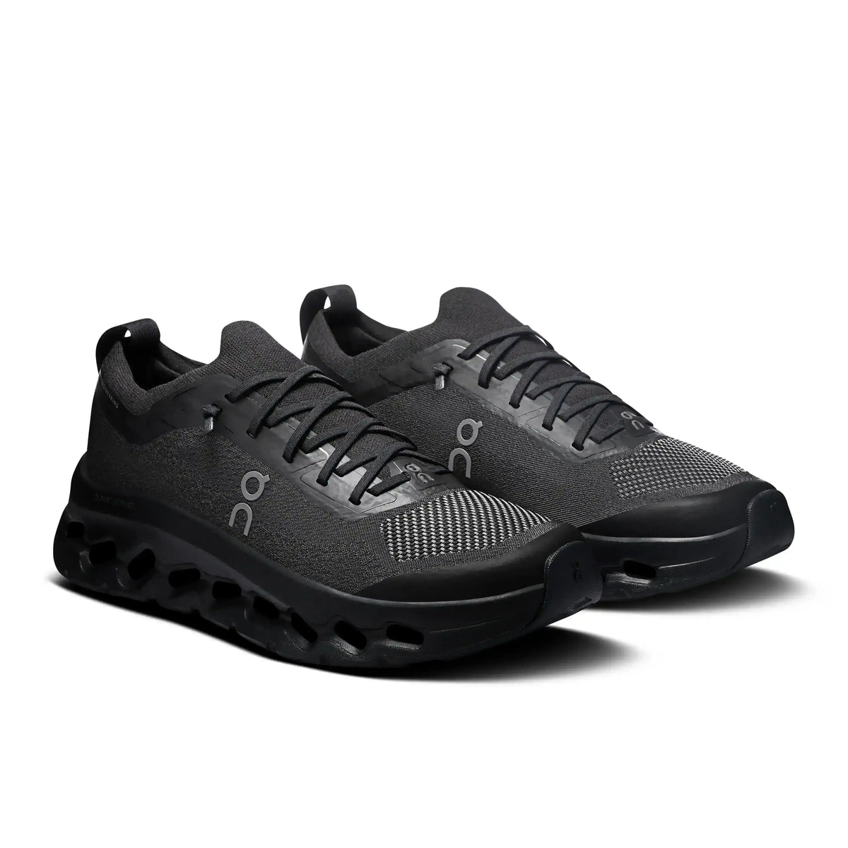 Black lace-up sneakers with cutout-style midsoles.