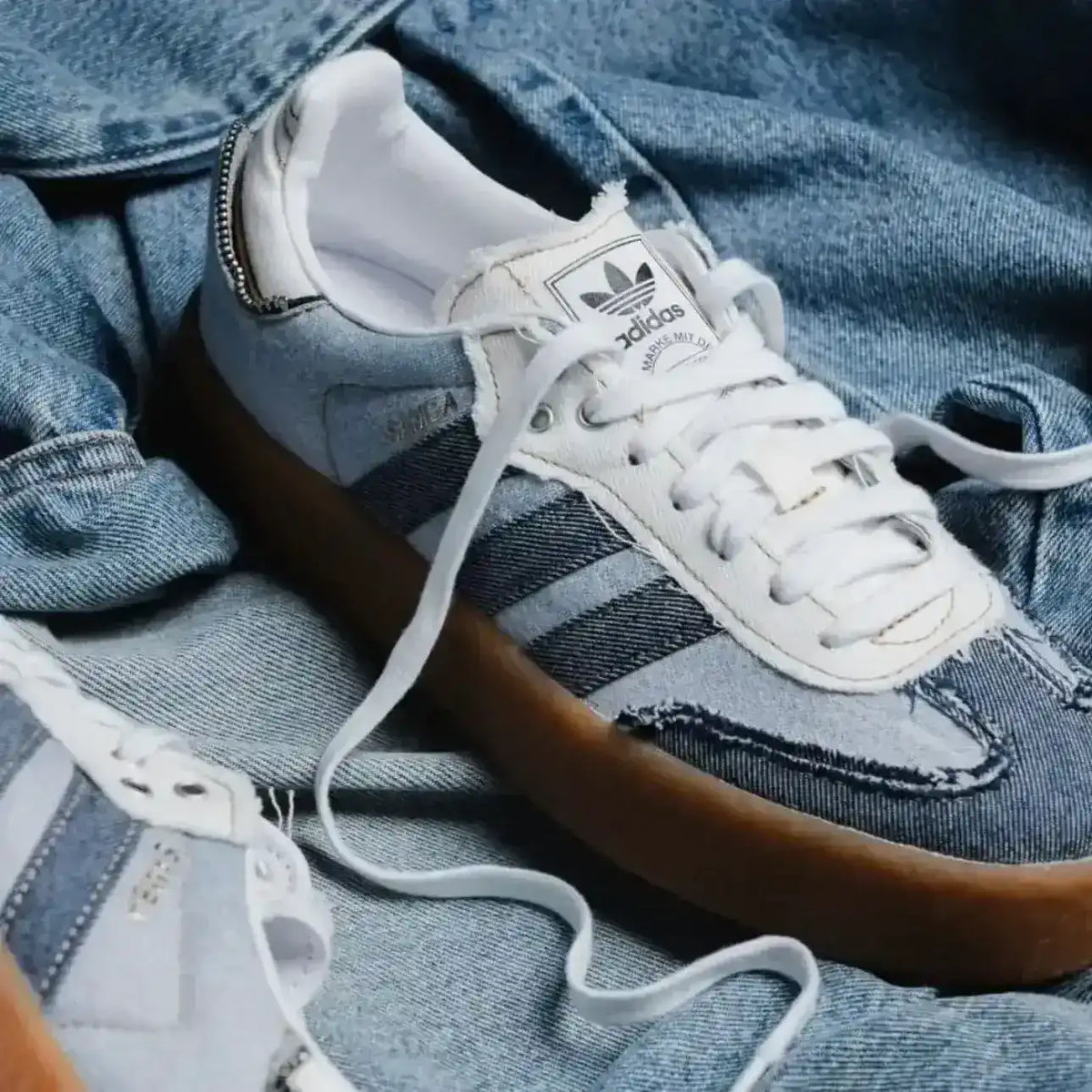 Blue denim-look low-top sneakers with pale laces and gum soles.
