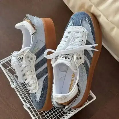 Blue denim-look low-top sneakers with pale laces and gum soles.