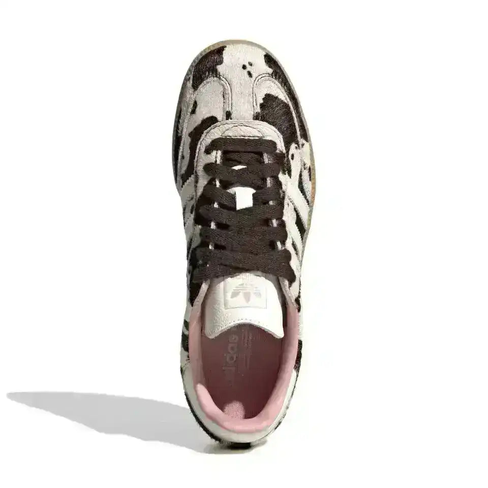 Cow-pattern low-top sneaker with dark laces, top view.