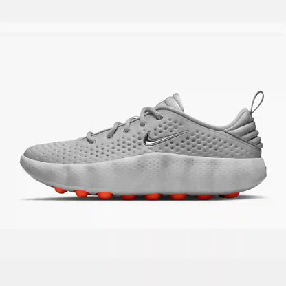 Gray mesh-panel sneaker with orange sole pods, side view.