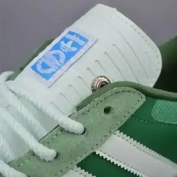 Green three-stripe low-top sneakers with gum soles.