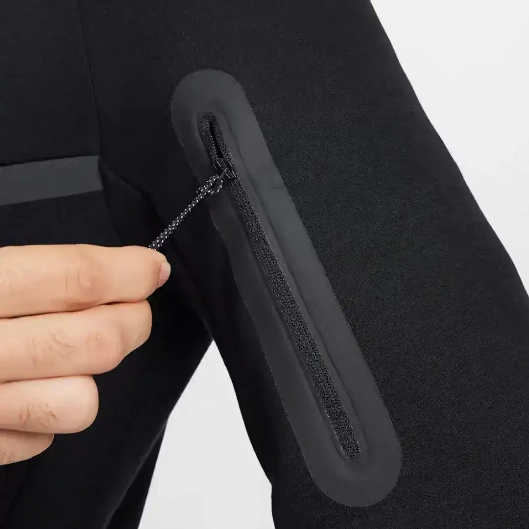 Close-up of a zip pocket on black jogger pants.