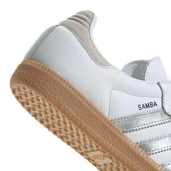 White low-top sneakers with silver-colored side stripes.
