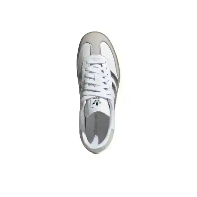 White low-top sneakers with silver-colored side stripes.