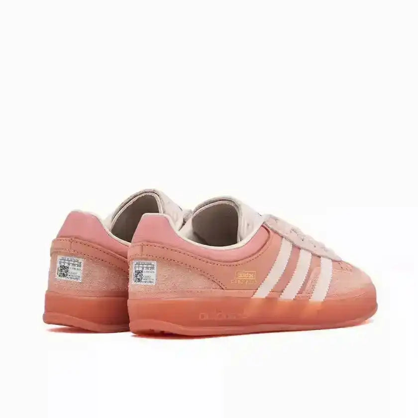 Coral pink three-stripe low-top sneakers with translucent-look soles.